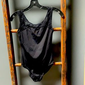 Children’s black sleeveless leotard with lace detail at the neck